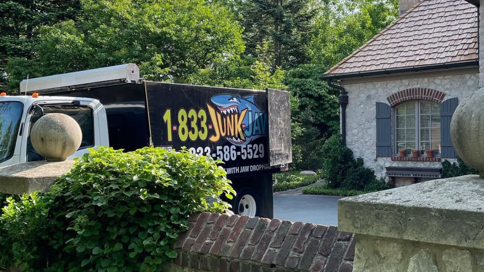 A Junk Jaws truck parked outside a suburban home during an estate cleanout