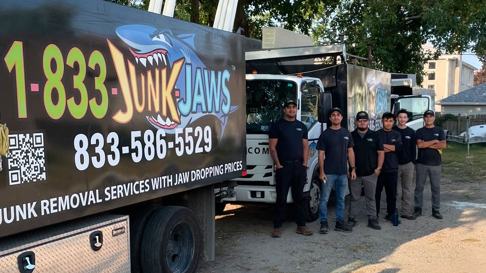 The Junk Jaws crew stands next to their trucks.