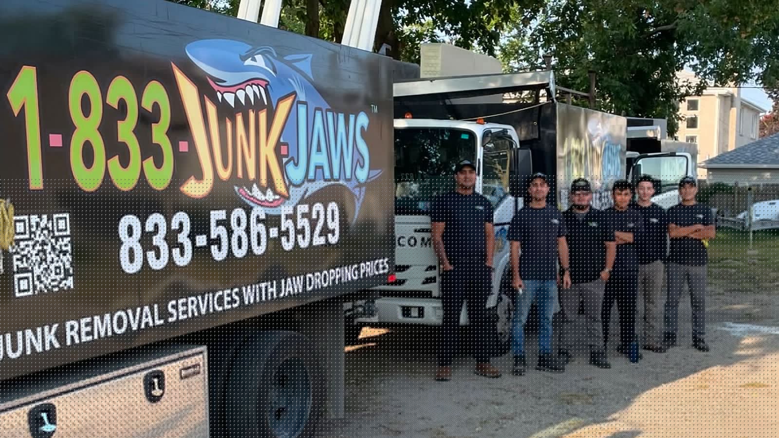 The Junk Jaws crew lined up in front of a branded 1-833-JUNK-JAWS truck