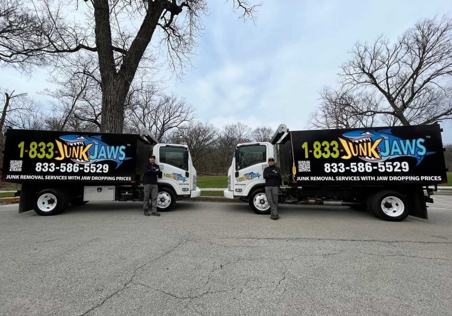 Three branded Junk Jaws trucks parked side by side before the morning routes