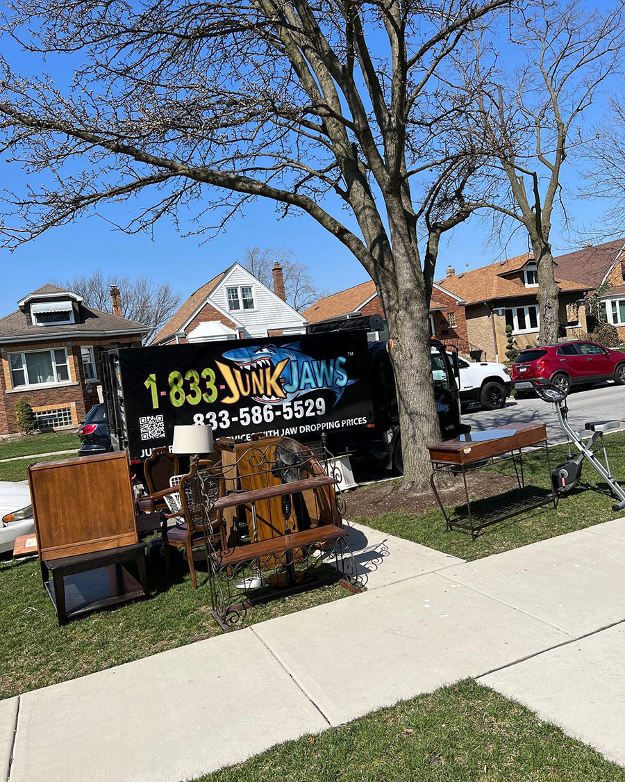 A Junk Jaws truck is parked in front of trash.