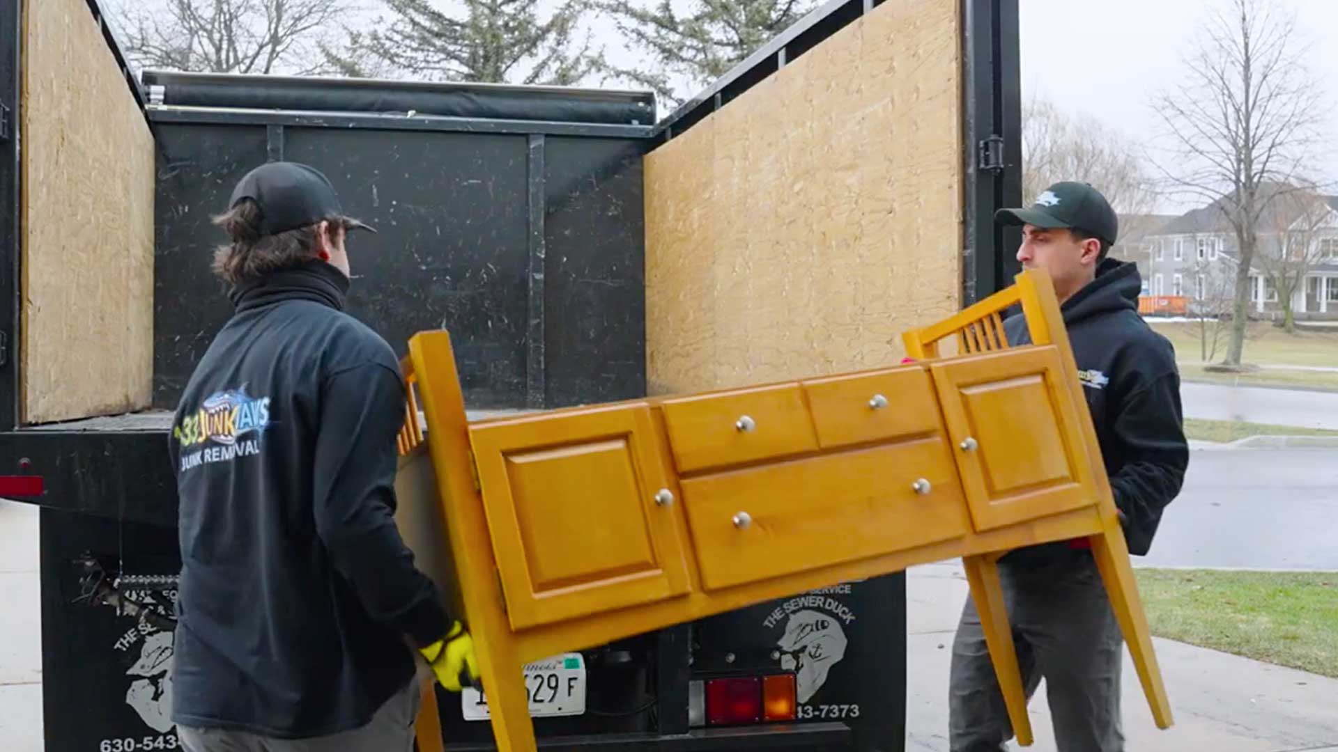 Junk Jaws employees loading furniture into their truck.