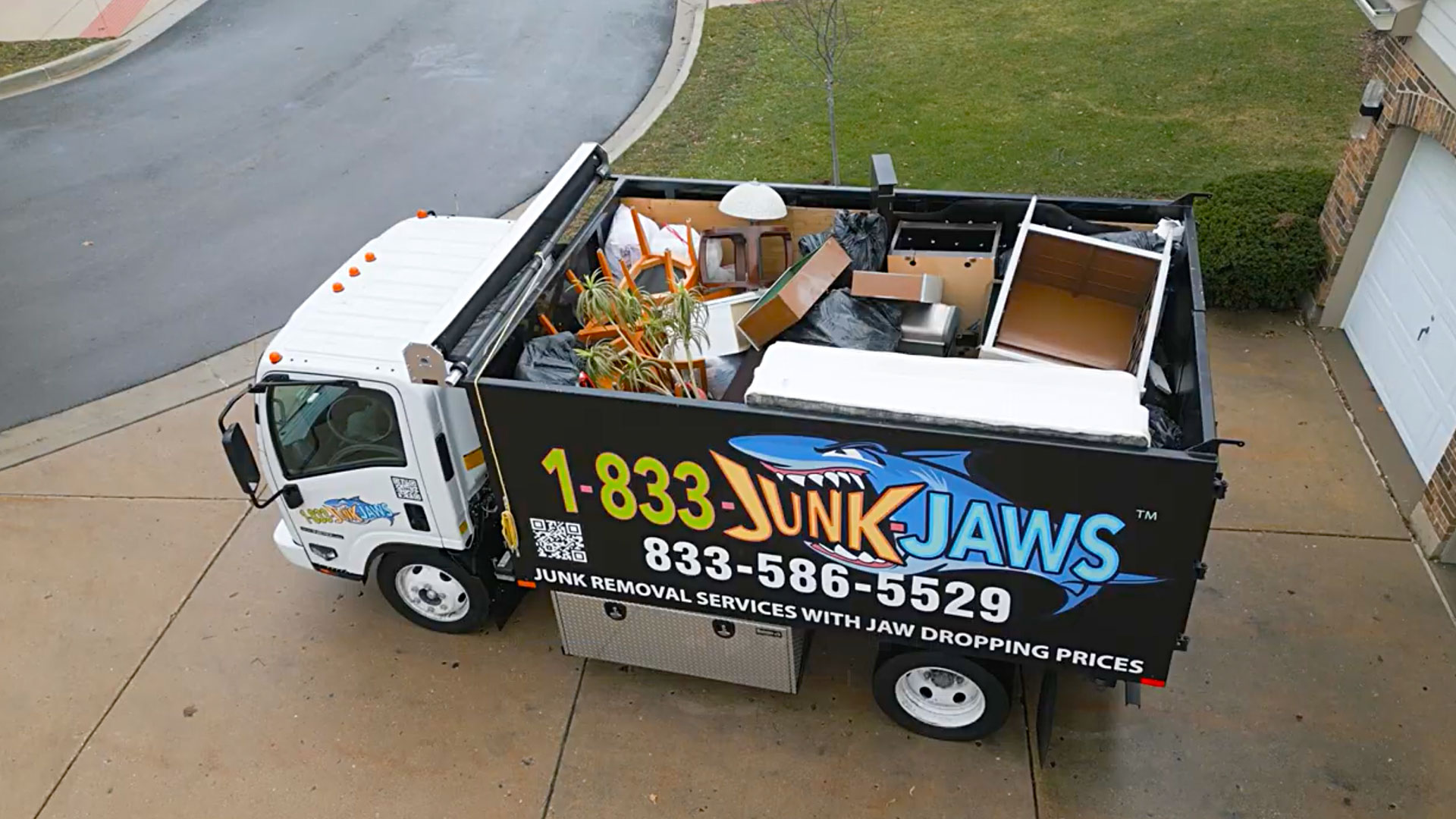 A Junk Jaws truck loaded with appliances and household junk.