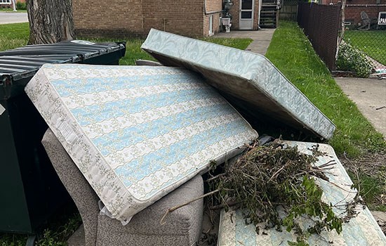 An old mattress and box spring set out curbside for Junk Jaws pickup