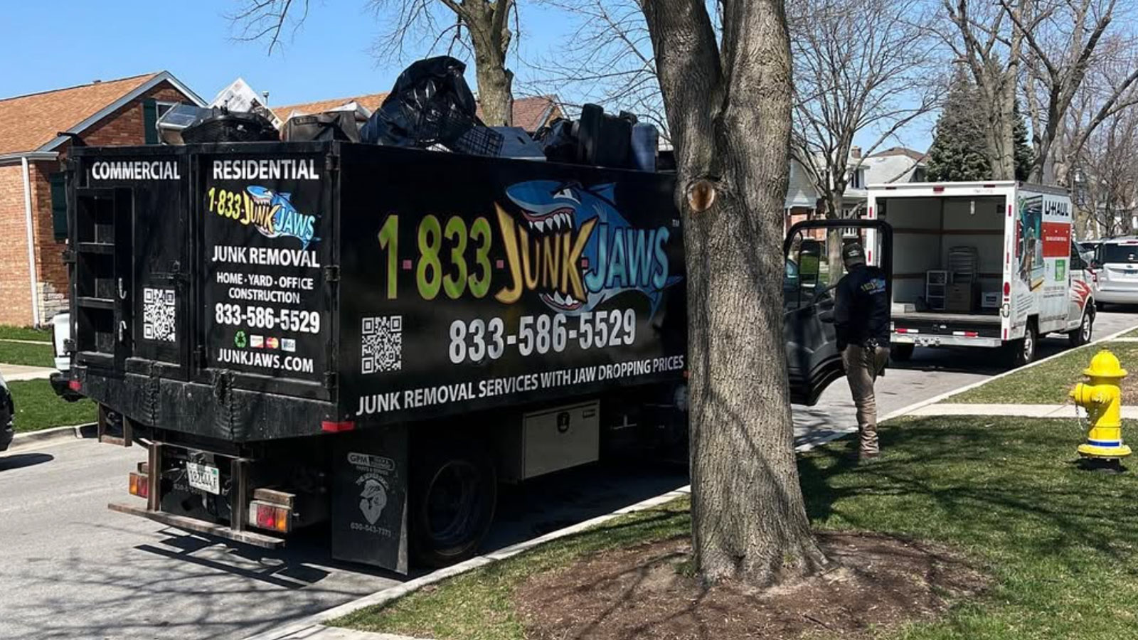A fully loaded Junk Jaws truck parked in front of a finished job.